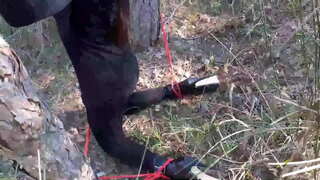 Laura na Petah model korak sestra v črni obleki in visokih petah, ki jo veže in prikriti v les, je, da sesati a bick petelin.